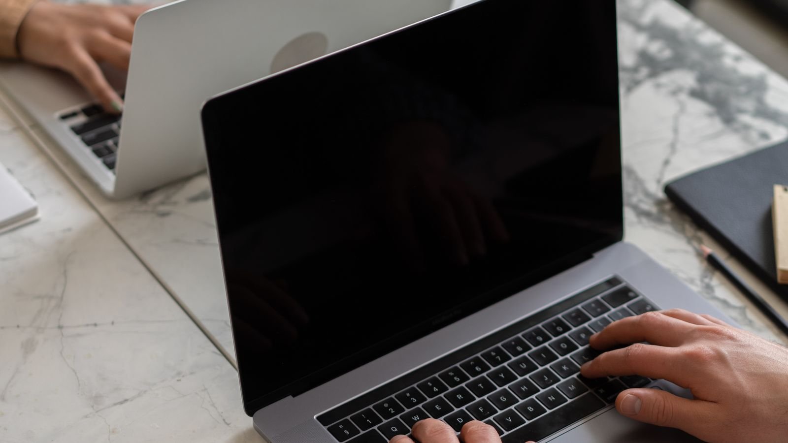 Laptop and notebook on a wooden desk