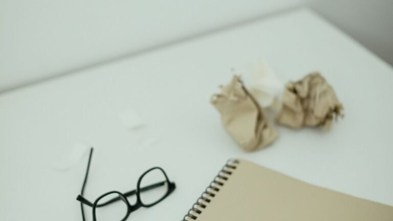 Open notebook and pen beside a tablet on a desk