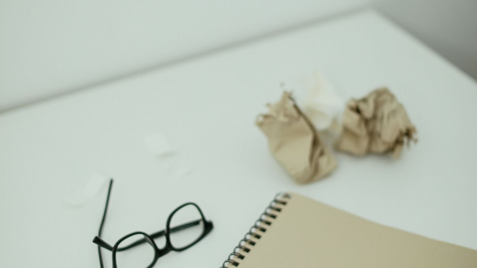 Open notebook and pen beside a tablet on a desk