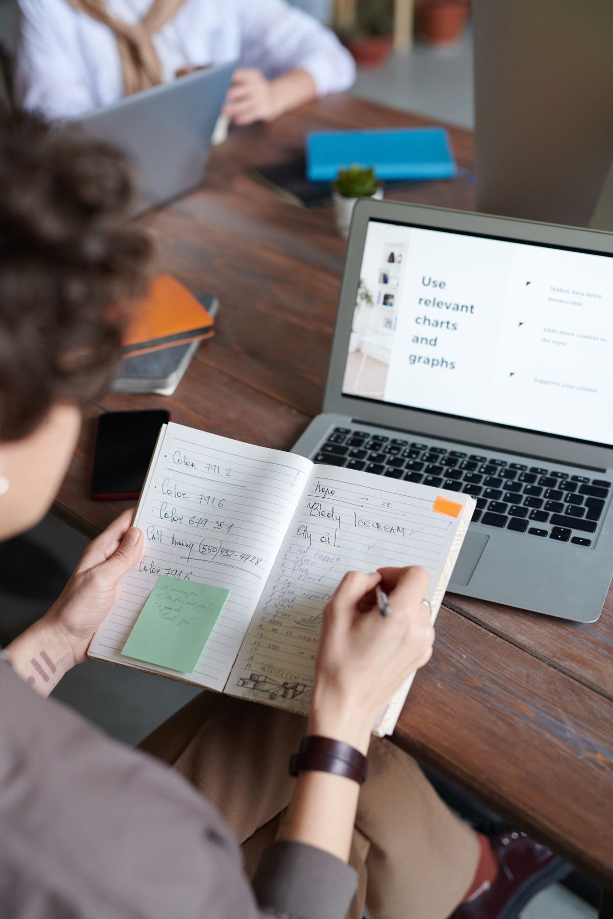 Person taking notes at a laptop showing a chart