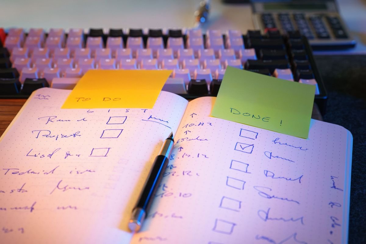 A to-do list with completed tasks in a notebook on a desk