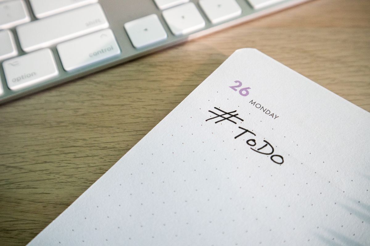 A to-do list on paper next to a computer keyboard