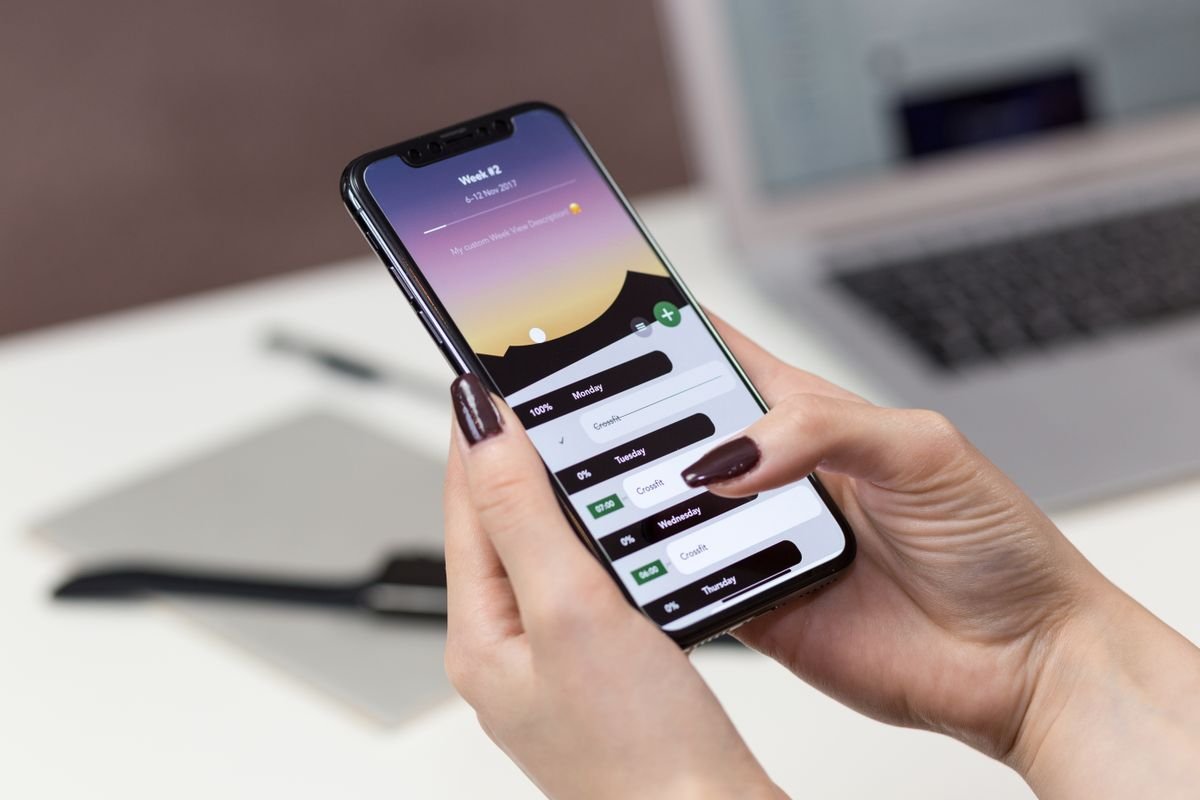 Person using a productivity app on a smartphone at a desk