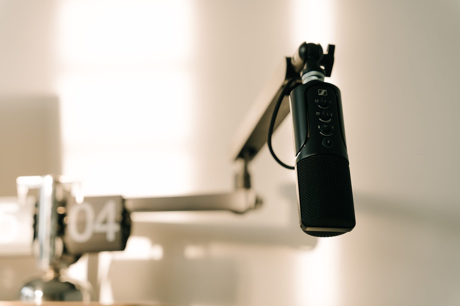 A professional microphone on a boom arm in a recording studio